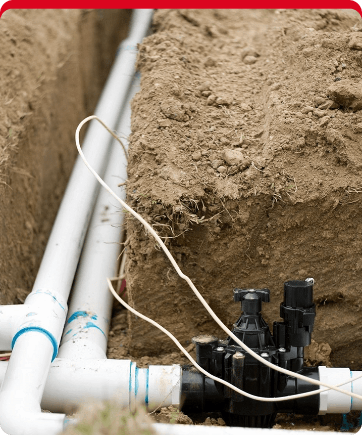 A pipe laying on top of the ground next to two pipes.