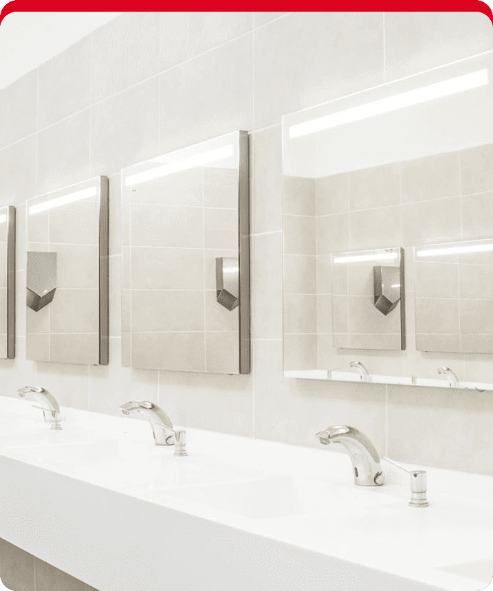 A row of mirrors in a bathroom with sinks.
