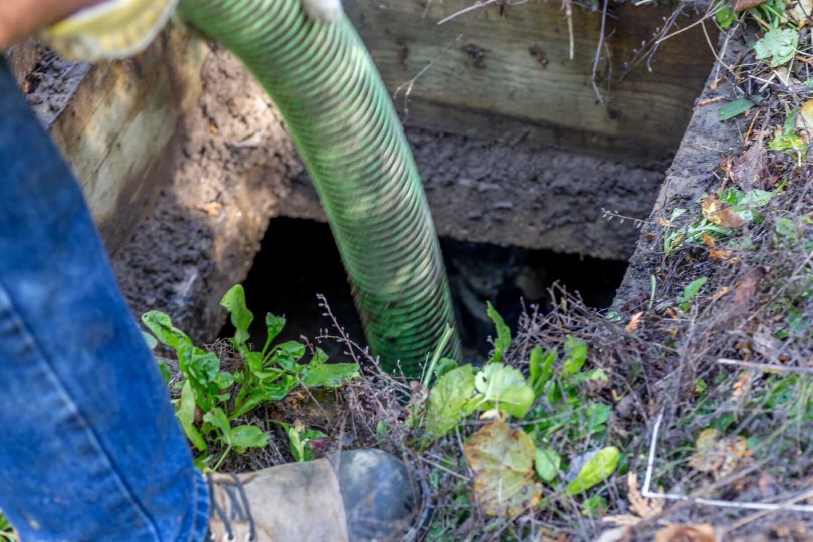 A person is using a hose to clean up the dirt.